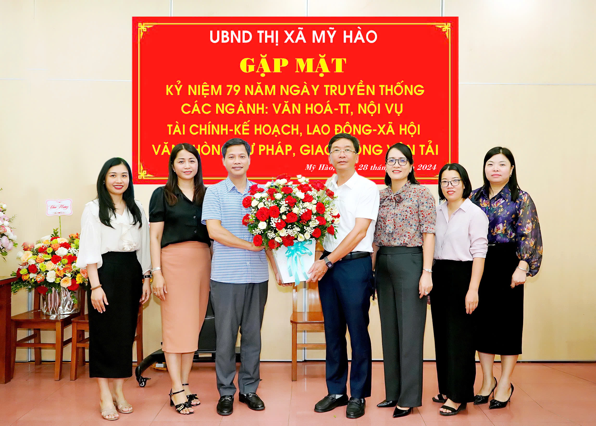 Đồng chí Phó Bí thư Thị ủy, Chủ tịch UBND thị xã Lê Quang Hiến tặng hoa chúc mừng kỷ niệm phòng Lao động - TB&XH thị xã