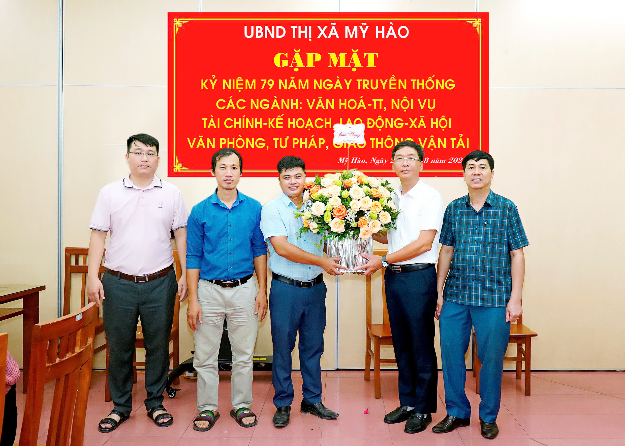 Đồng chí Phó Bí thư Thị ủy, Chủ tịch UBND thị xã Lê Quang Hiến; đồng chí Phó Chủ tịch UBND thị xã Nguyễn Quốc Khánh tặng hoa chúc mừng phòng Quản lý Đô thị thị xã