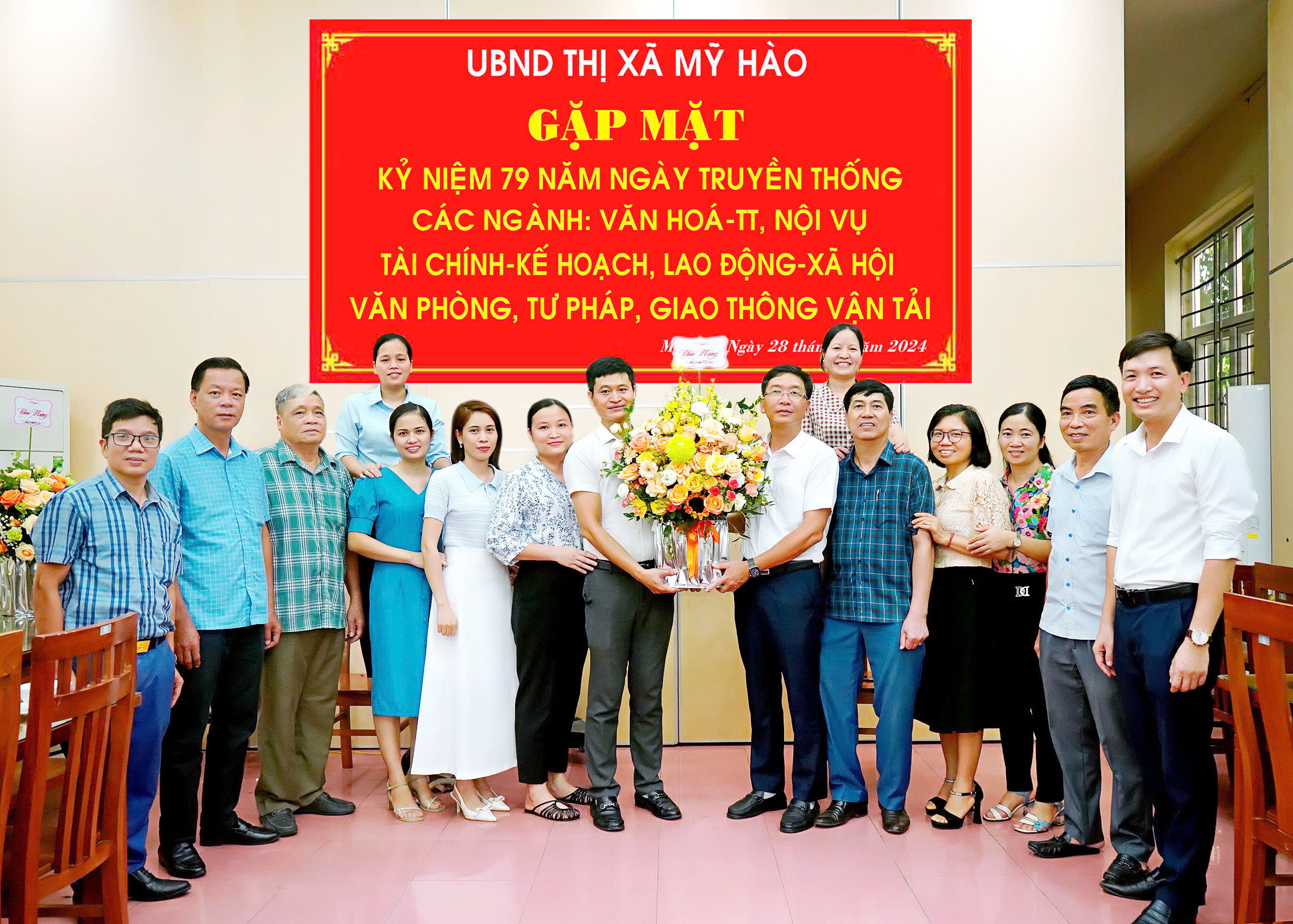 Đồng chí Phó Bí thư Thị ủy, Chủ tịch UBND thị xã Lê Quang Hiến; đồng chí Phó Chủ tịch UBND thị xã Nguyễn Quốc Khánh tặng hoa chúc mừng Văn phòng HĐND và UBND thị xã