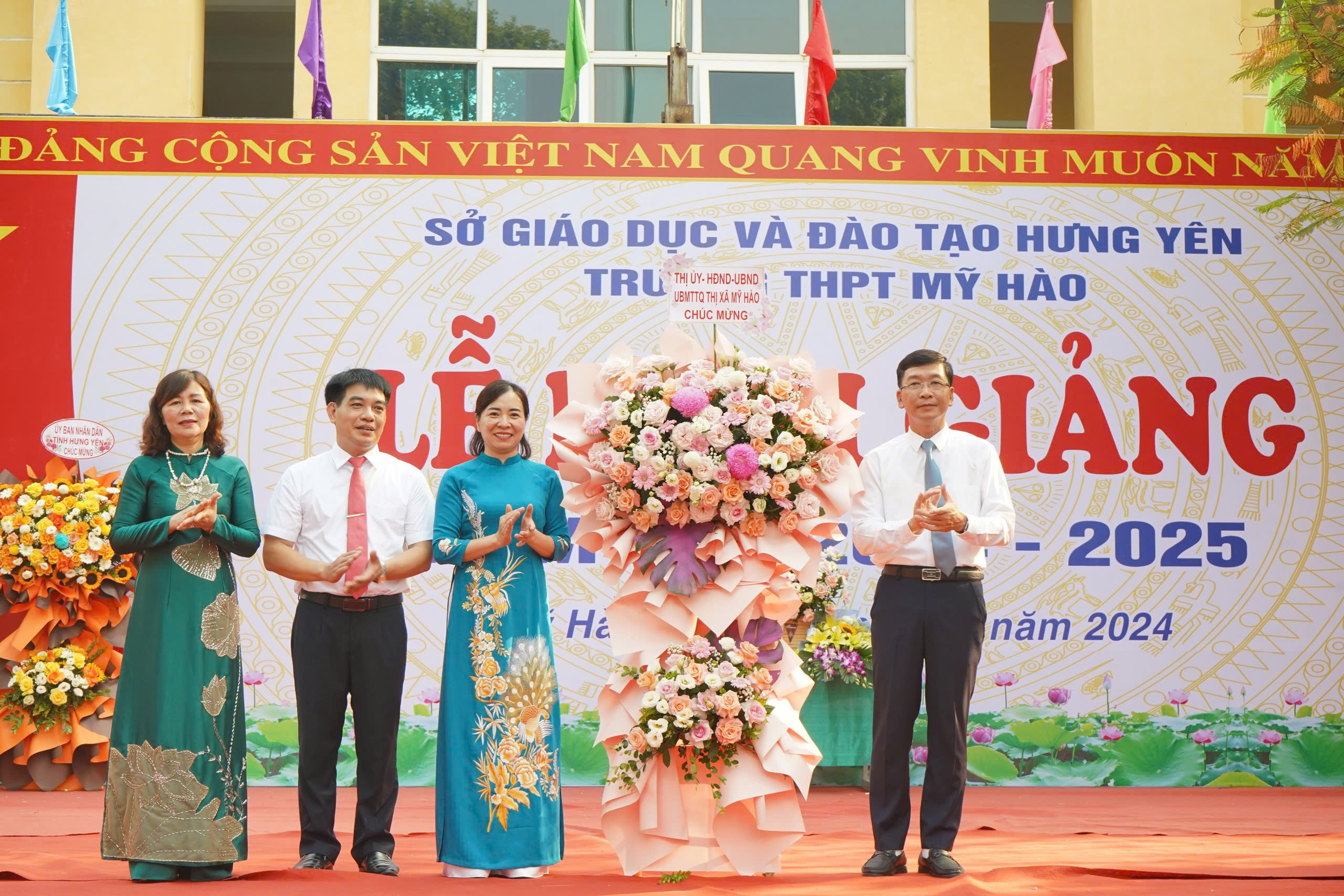 Đồng chí Lê Quang Hiến, Phó Bí thư Thị ủy, Chủ tịch UBND thị xã tặng hoa chúc mừng Trường THPT Mỹ Hào