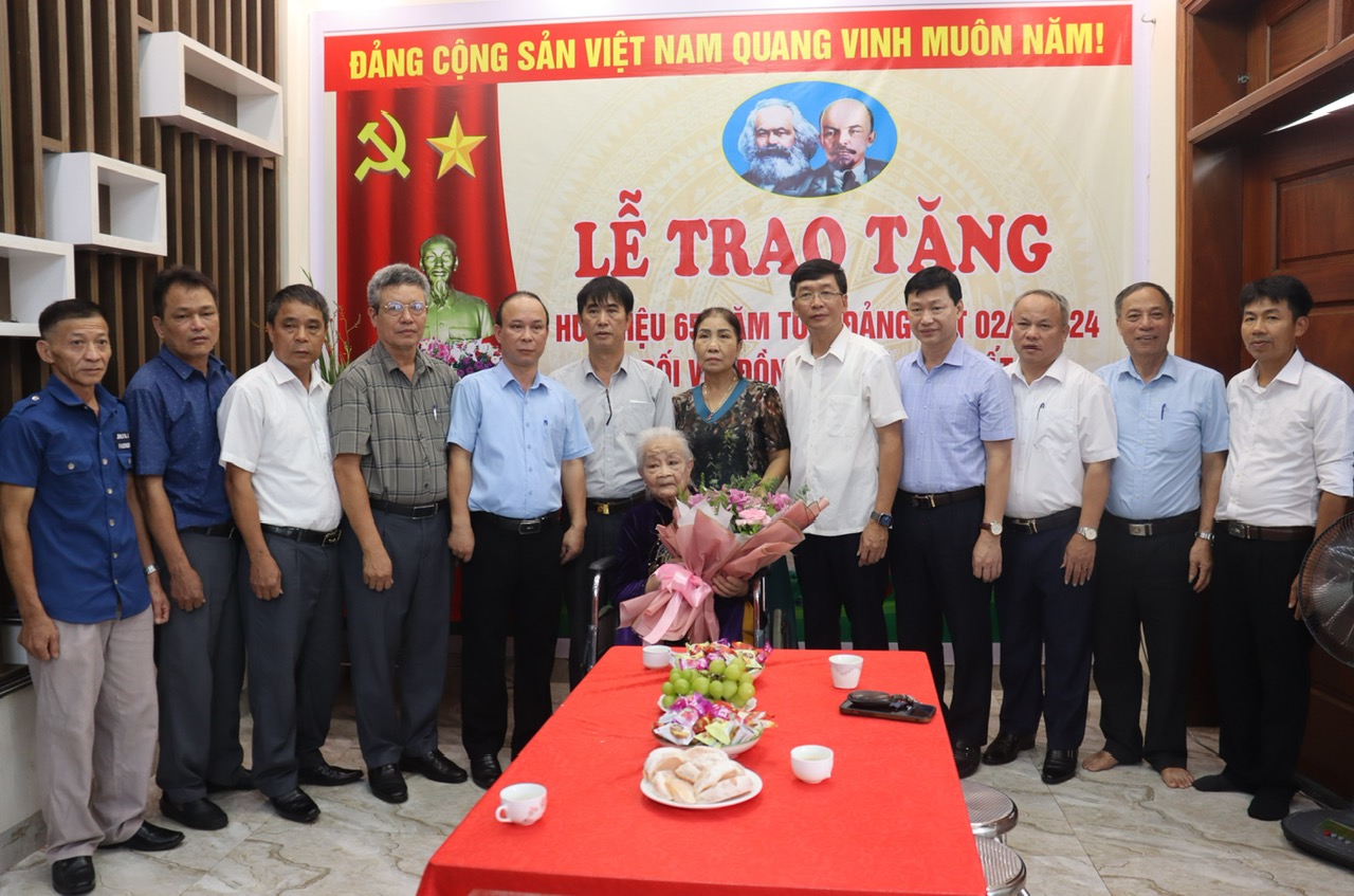 Đồng chí Lê Quang Hiến, Phó Bí thư Thị ủy, Chủ tịch UBND thị xã cùng các đồng chí là lãnh đạo UBND phường Phùng Chí Kiên chụp ảnh lưu niệm với đảng viên Đào Thị Tất