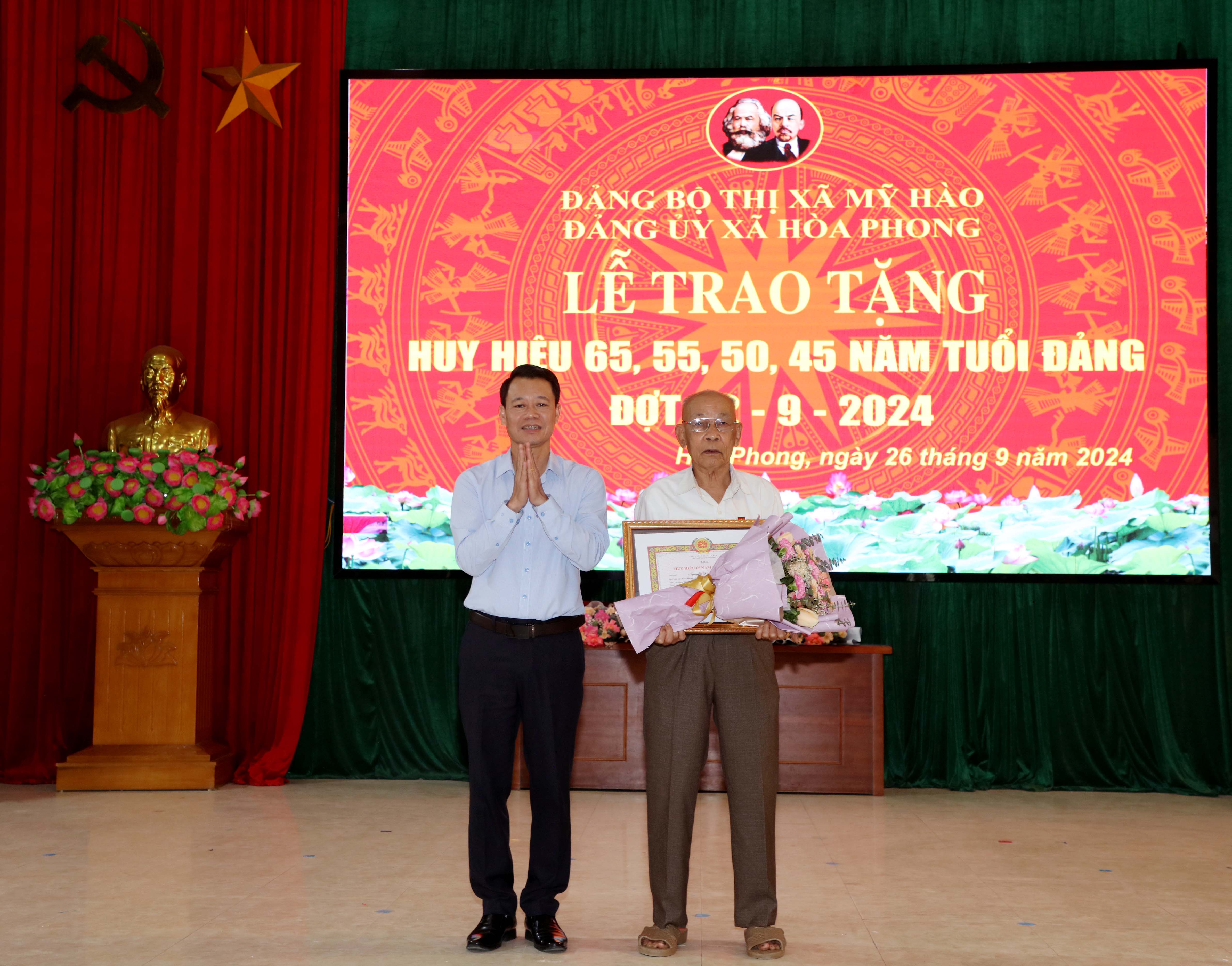 Đồng chí Đào Quang Minh, Phó Bí thư Thường trực Thị ủy, Chủ tịch HĐND thị xã trao Huy hiệu Đảng cho đảng viên Nguyễn Đình Chạ